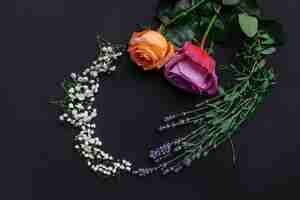 Bezpłatne zdjęcie rama wianek wzór ze świeżych kwiatów na czarnym tle