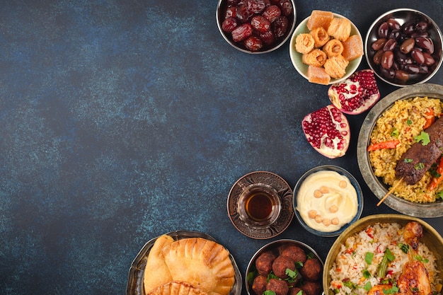 Ramadan kareem iftar stół imprezowy z różnymi świątecznymi tradycyjnymi arabskimi potrawami, słodyczami, daktylami. eid al-fitr mubarak wieczorem wielki posiłek, widok z góry. islamskie święta jedzenie, uczta ramadanowa, miejsce na tekst