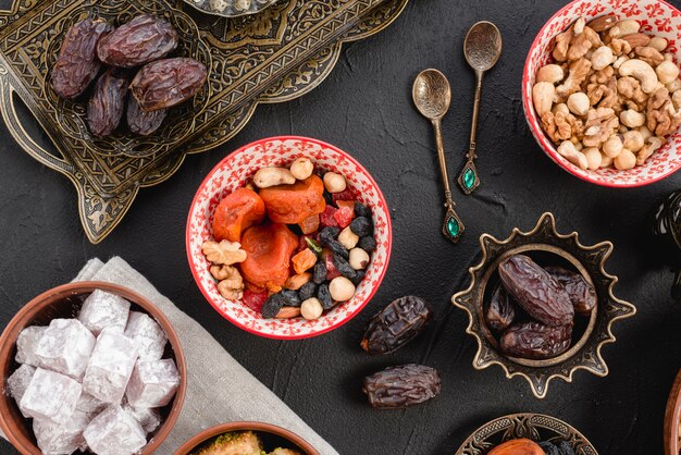 Ramadan soczyste daktyle i suszone owoce; orzechy i lukum na czarnym tle