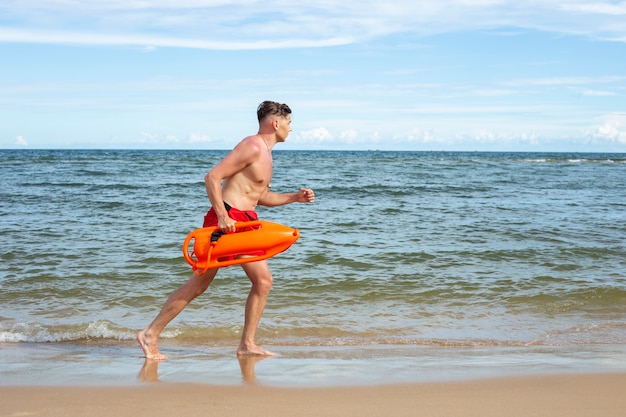 Ratownik z pełnym strzałem biegający na plaży