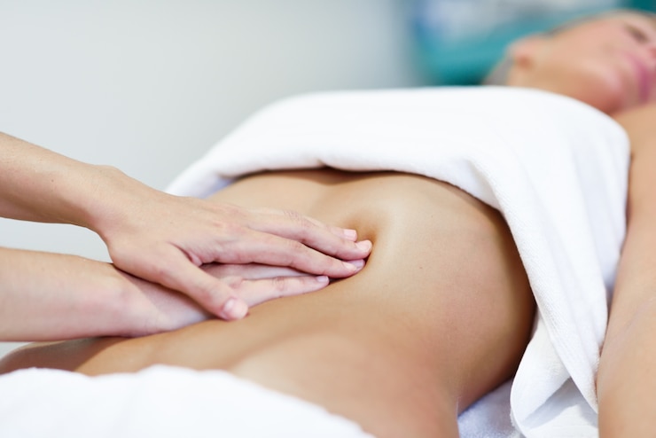 Bezpłatny plik Zdjęcie ręce kobiety masażu abdomen.therapistę stosowania ciśnienia na brzuchu.