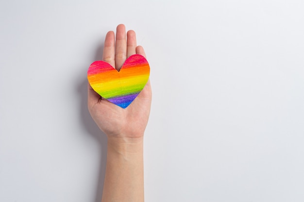 Ręce kobiety trzymają świadomość tęczowego serca dla koncepcji dumy społeczności LGBT