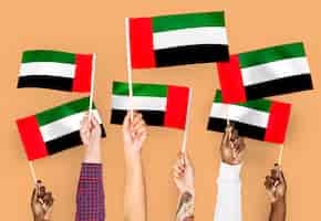 Bezpłatne zdjęcie ręce macha flagami zjednoczonych emiratów arabskich