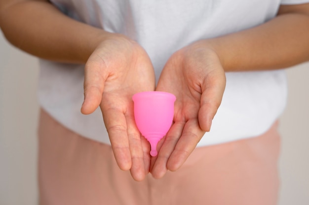 Ręce o wysokim kącie trzymające miseczkę menstruacyjną