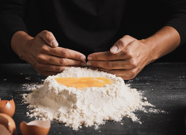 Ręce piekarza mieszanie żółtka z mąką