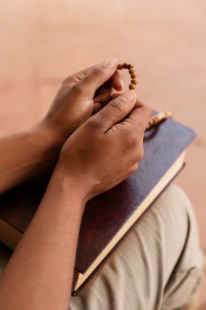 Bezpłatne zdjęcie ręce pod wysokim kątem na świętej biblii