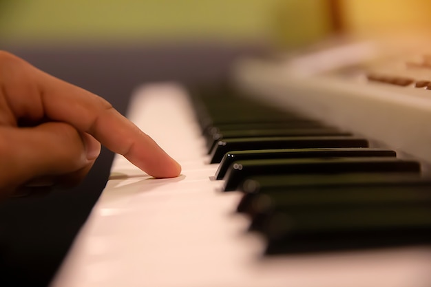 Ręce przyciśnięte do klawiatury fortepianu.