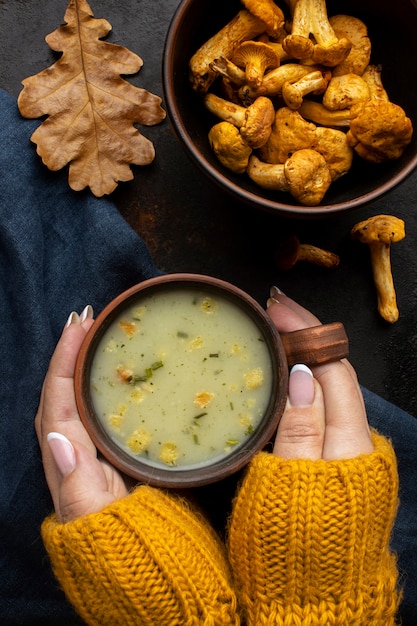 Bezpłatne zdjęcie ręce, trzymając w filiżance zupa grzybowa