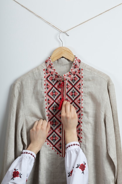 Bezpłatne zdjęcie ręce układające tradycyjną haftowaną koszulę