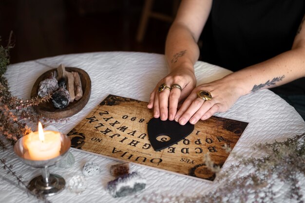 Ręce używające drewnianej tablicy ouija pod wysokim kątem