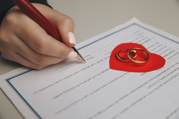 Ręce żony, podpisanie przez męża dekretu rozwodowego, rozwiązania, unieważnienia małżeństwa, dokumentów separacji