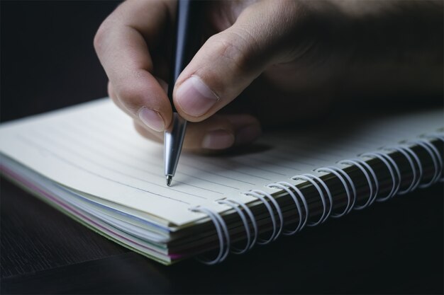 Ręczne pisanie piórem na notebooku.