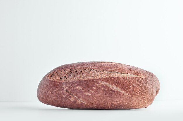 Ręcznie robiony owalny chleb na szarym stole.