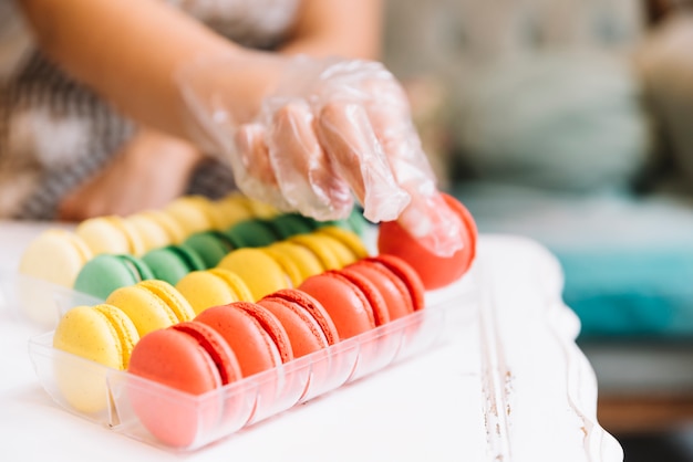 Bezpłatne zdjęcie ręka bierze kolorowego macaron