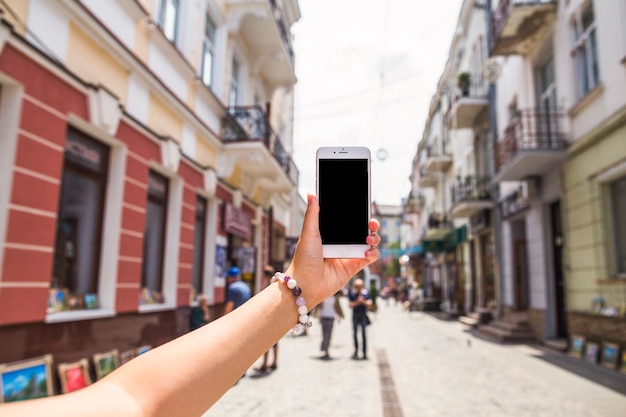 Ręka bierze obrazek ruchliwa miasto ulica przez telefonu komórkowego