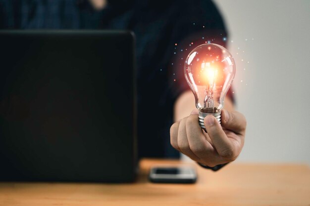 Ręka biznesmena trzymająca żarówkę ze świecącym światłem do kreatywnego inteligentnego myślenia dla inspiracji i innowacji z koncepcją sieci