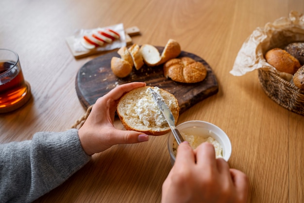 Bezpłatne zdjęcie ręka pod dużym kątem trzymająca kromkę chleba