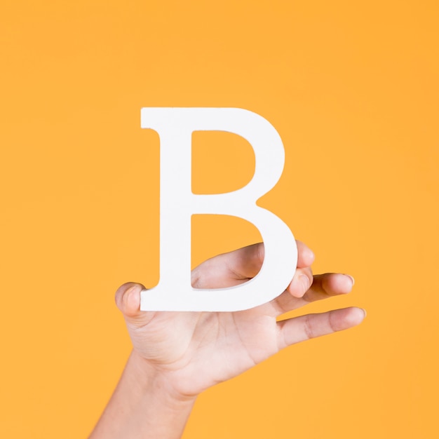 Ręka pokazuje białą wielką literę b