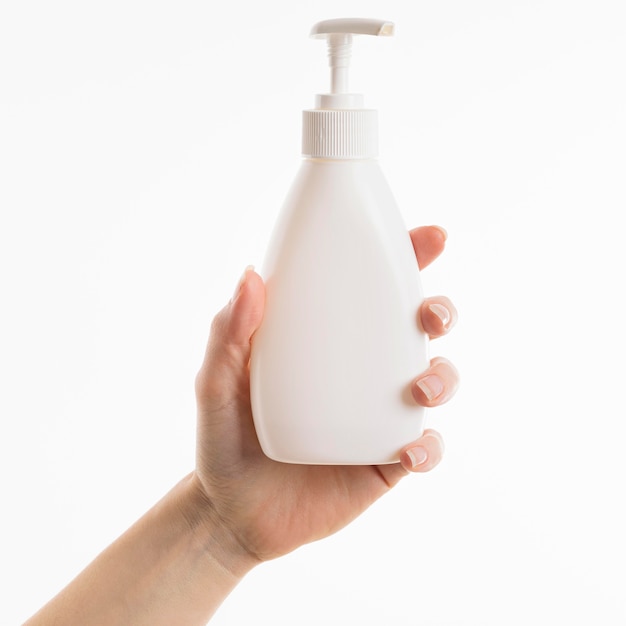 Bezpłatne zdjęcie ręka trzyma butelkę mydła w płynie