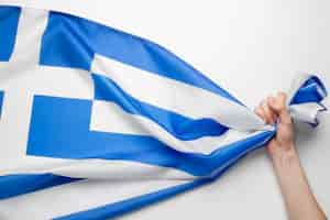 Bezpłatne zdjęcie ręka trzyma tkaninę z flagą grecji