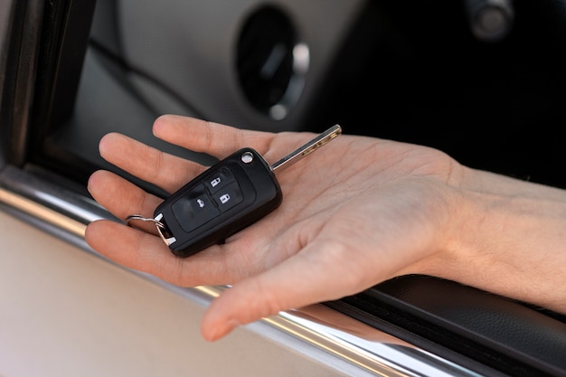 Bezpłatne zdjęcie ręka trzymająca kluczyk samochodowy pod dużym kątem