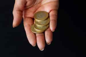 Bezpłatne zdjęcie ręka trzymająca monety pod wysokim kątem
