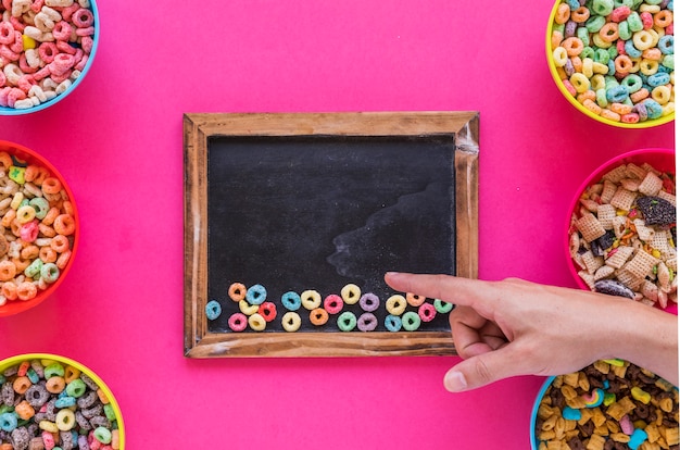 Bezpłatne zdjęcie ręka wskazuje palec przy chalkboard z zbożami