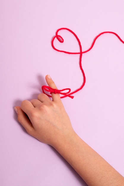 Ręka z czerwoną nicią w kształcie serca
