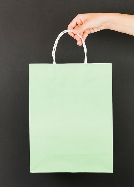 Ręka z zielonym pakietem zakupów