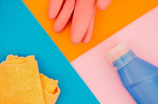 Rękawiczki; serwetka i butelka na pomarańczowym; niebieskie i różowe tło