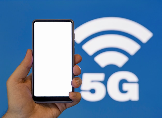 Ręki mienia telefon z 5g symbolu tłem