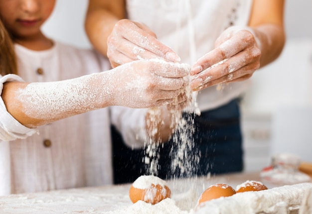 Ręki nalewa mąkę na jajka