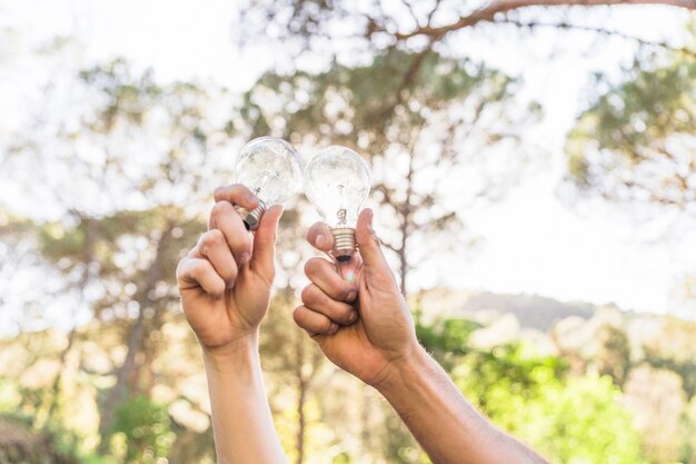 Ręki trzyma lampy przeciw naturze