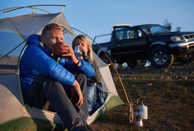 Rekreacja pary obozowiczów w namiocie na świeżym powietrzu