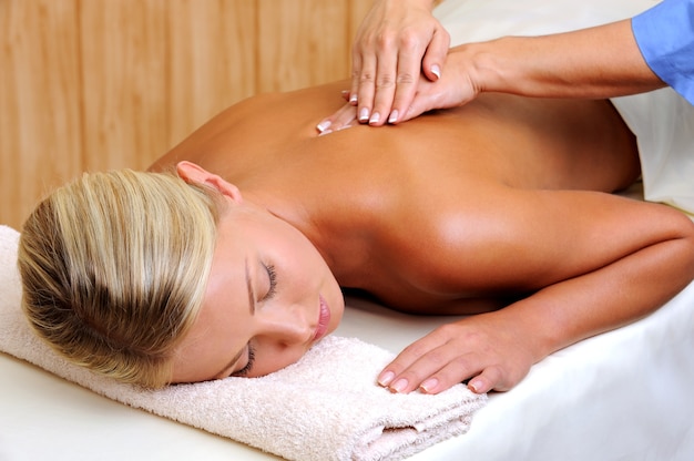 Relaksacyjny masaż dla młodej kobiety w gabinecie kosmetycznym