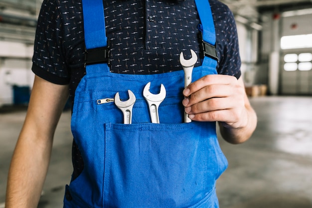 Bezpłatne zdjęcie repairmen bierze klucz od kombinezonu przy garażem