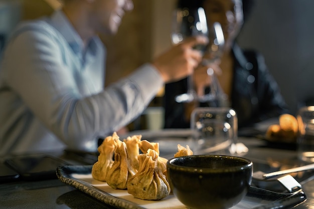 Restauracyjny stół z tradycyjnymi chińskimi pierożkami dim sum rozmyty ludzi w tle