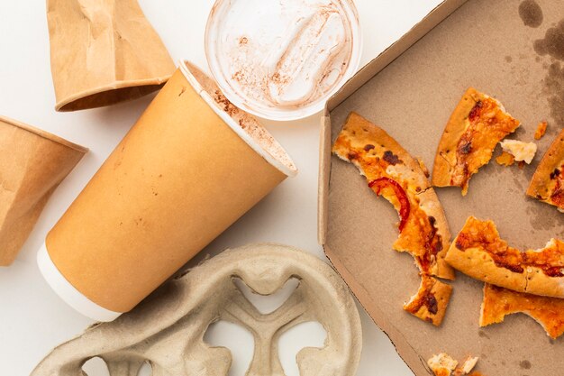 Resztki pizzy i jednorazowy kubek