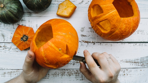 Bezpłatne zdjęcie robiąc halloween rzeźbiącej bani