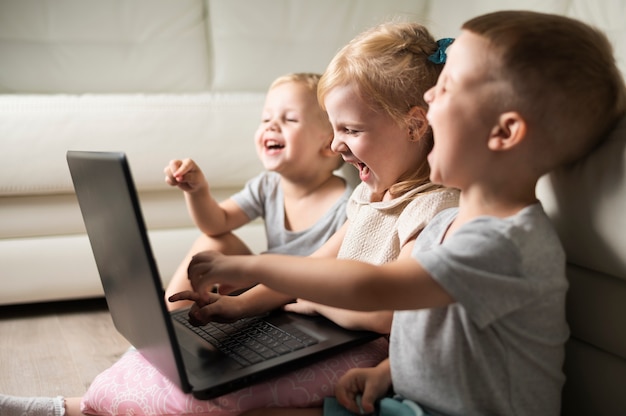 Rodzeństwo buźki w domu oglądając na laptopie