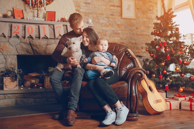 Rodzina siedzi na kanapie z psem na Boże Narodzenie
