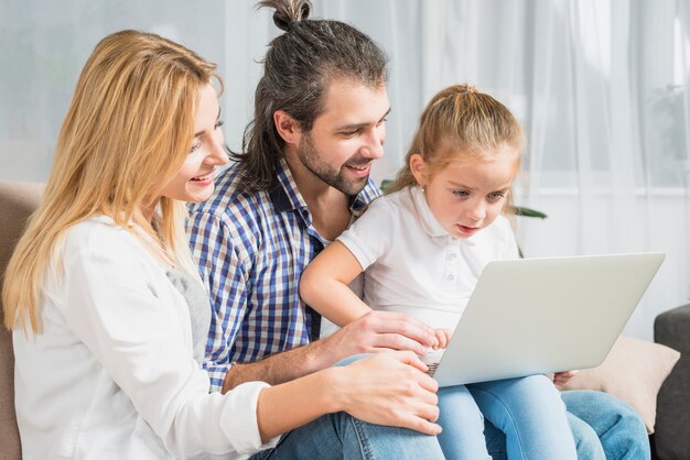 Rodzina używa laptop na kanapie