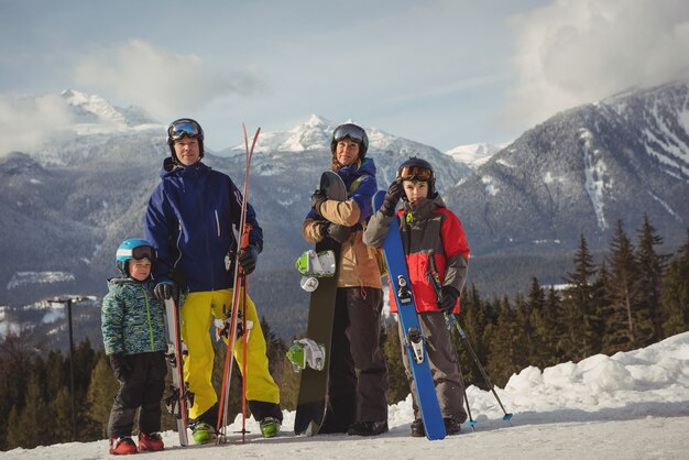 Rodzina w odzieży narciarskiej stojąc razem na zaśnieżonych Alpach