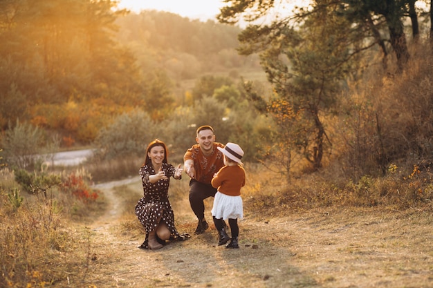 Rodzina z ich małą córeczką w polu jesienią