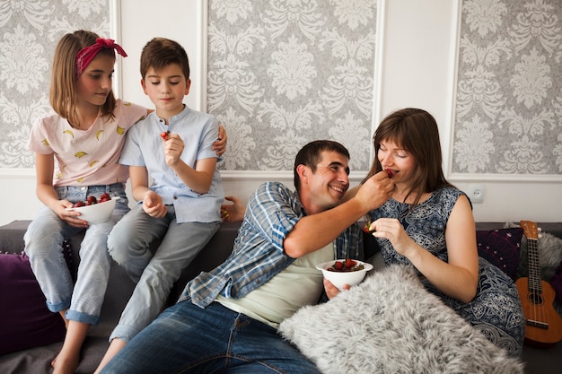 Rodzinny obsiadanie na kanapie i cieszyć się truskawki w domu