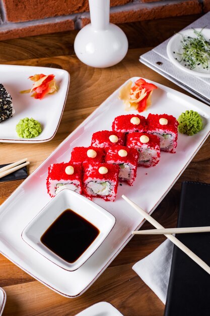 Roladki sushi z kawiorem tobiko podawane z sosem sojowym, imbirem i wasabi