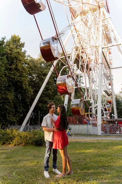 Bezpłatne zdjęcie romantyczna para razem na diabelskim młynie w parku