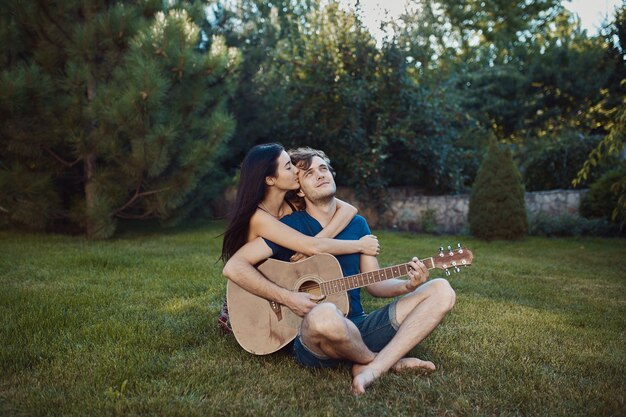 Romantyczna para siedzi na trawie w ogrodzie