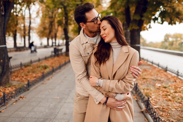Bezpłatne zdjęcie romantyczne chwile. szczęśliwa piękna para zakochanych wygłupia się i bawi w niesamowitym jesiennym parku.
