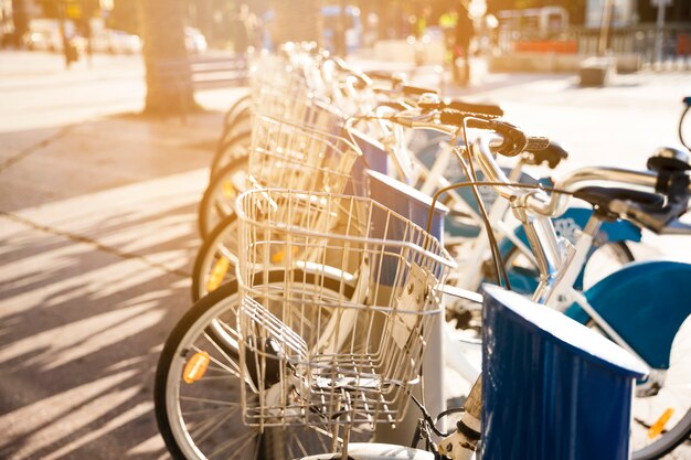 Rowery miejskie z metalowym koszem do wynajęcia stoją w rzędzie na brukowanej uliczce